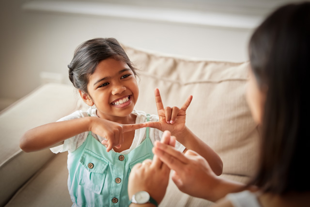 Little girl using sign language to communicate with her mother