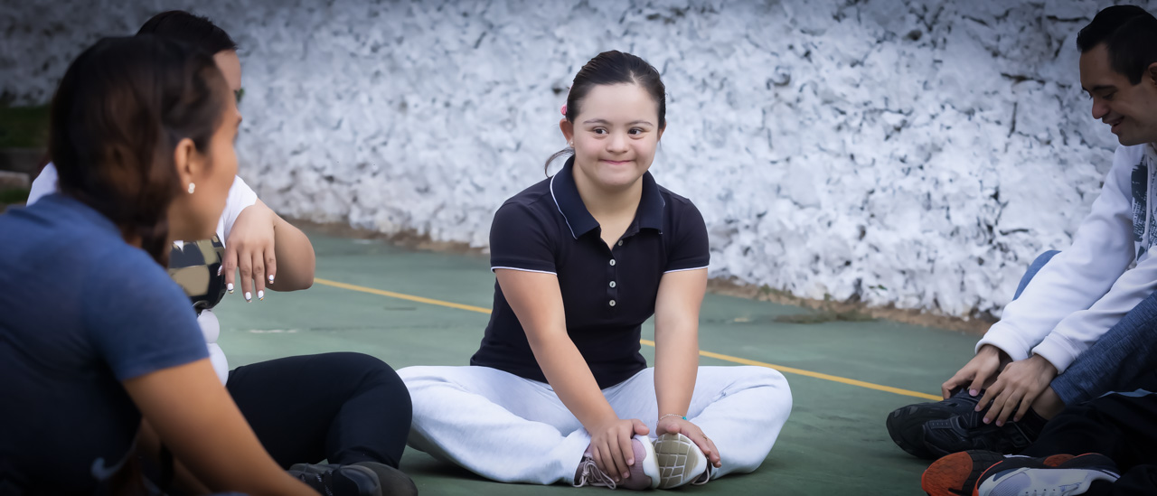 Group of young people with down syndrome doing stretching exercises.