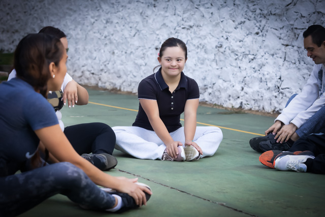 Group of young people with down syndrome doing stretching exercises.