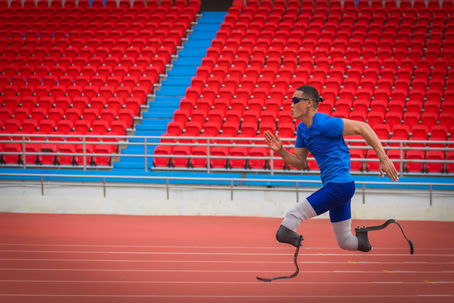 Athlete speeds up on stadium track, aiming to break his record with prosthetic blades