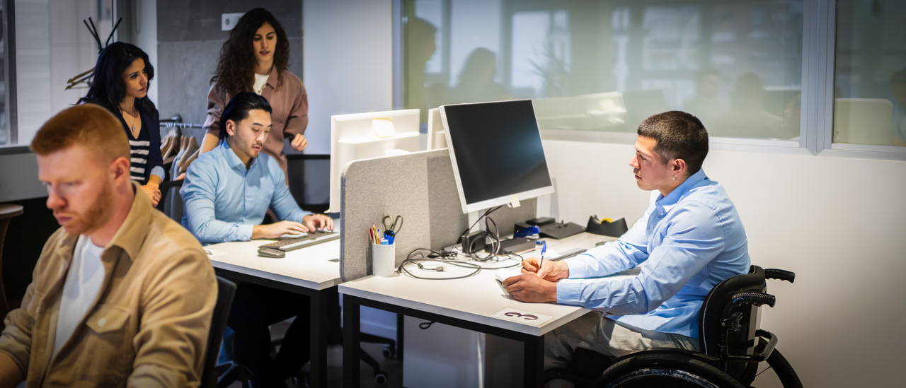 Young professionals collaborating in office, including a person with disability.